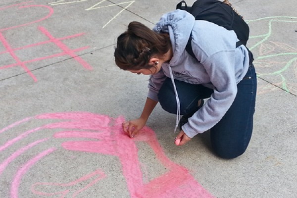 engineering student Julia Costa chalks a message