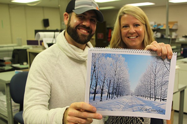 Scott Thorpe and Jen Almeida of the University Print Shop brandish a custom calendar of the sort they can design for holiday gift-givers.