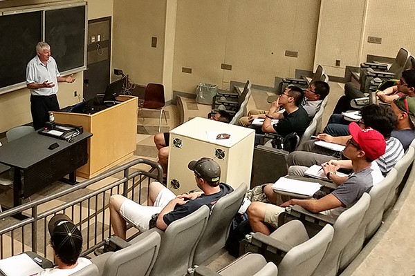 Mike Blundell addresses a classroom of students