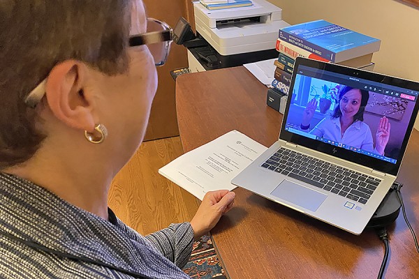 woman looking at breathing exercise leader on laptop