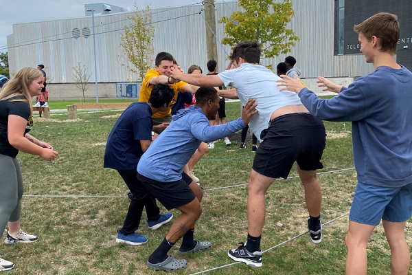 students engaging in ropes course as team