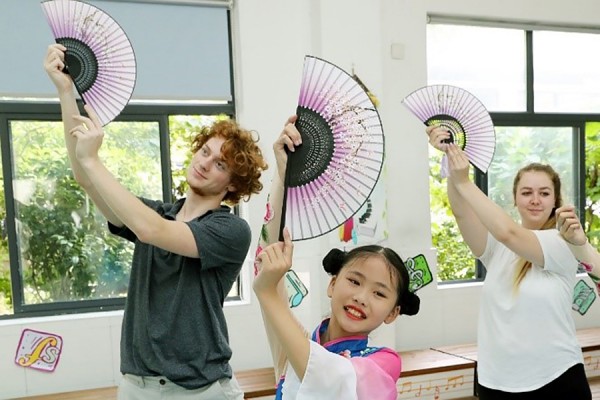 Education students George Paterson and Caroline Voyer follow a youthful instructor through a traditional dance during their visit to Changlang Primary School in Suzhou, China.