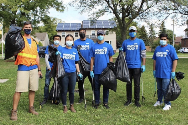 Students wearing Windsor Proud T-shirts and holding bags of litter.