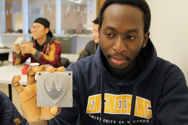 Dimi Olisa shows off the Lancer logo plaque he designed in his third-year CAD/CAM course.
