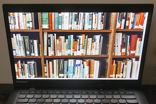 laptop displaying shelf of books