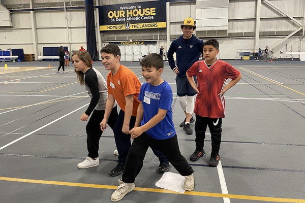 Lancer baseball co-captain Colin Jeun teaches kids how to run bases