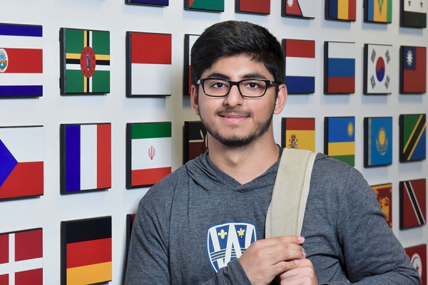 student standing against flag display in International Student Centre
