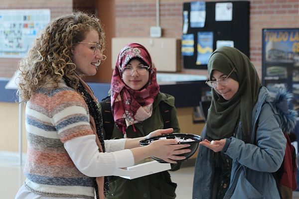 Kate Rosser-Davies gives free candies to nursing students Zahraa and Dina Al Maamouri