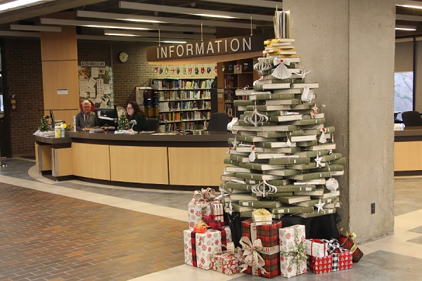 pile of books forming tree shape in front of circulation desk