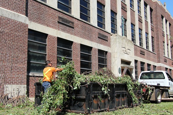 Groundskeeper Mike Mehenka clears ivy vines that had been removed from the exterior of Memorial Hall.