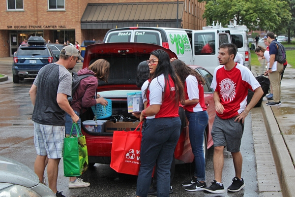 family unloading vehicle on residence move-in day