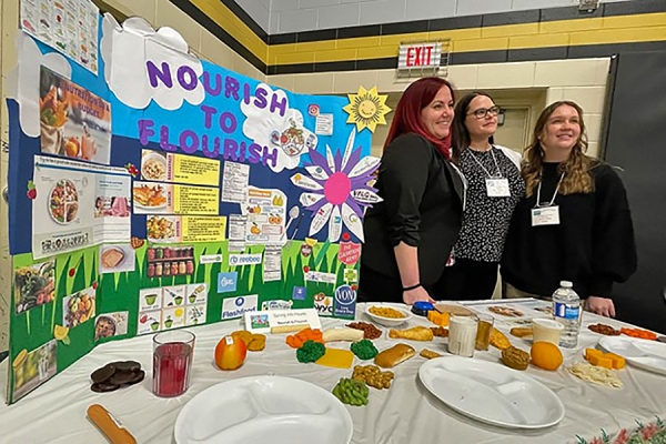 nursing students in front of healthy eating display