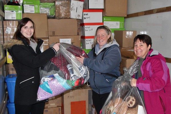Sabina Howell, Lee Ann Davey, Tara Munro carry parcels into a truck