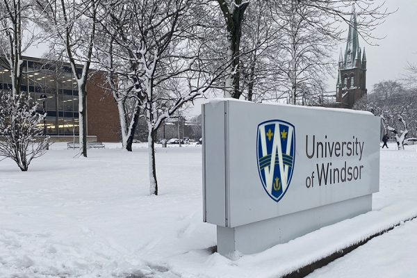 snow covering lawns, trees and signs at north end of campus