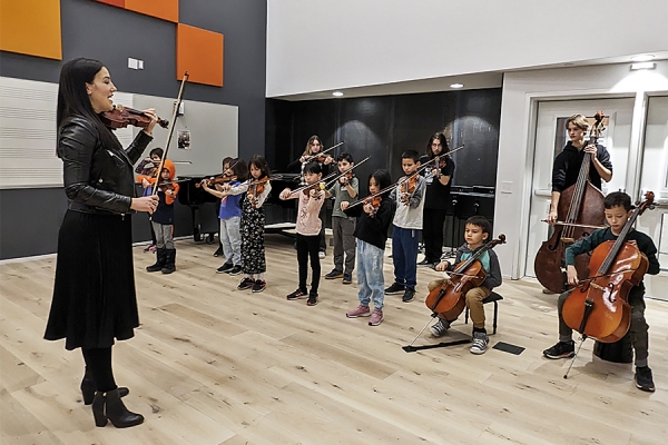 Vanessa Mio-Quiring conducting young people on violin, viola, cello, bass