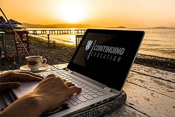 laptop on beach displaying text &quot;Continuing Education&quot;