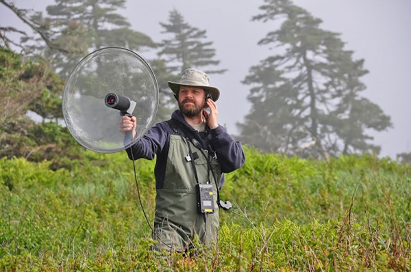 UWindsor biology associate professor Dan Mennill records the acoustic communication of a Savannah Sparrow on Kent Island.