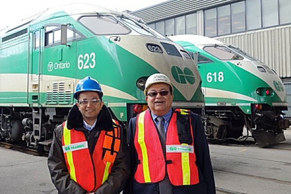 Ahmed Fayek and UWindsor engineering professor Waguih ElMaraghy pose in front of GO trains.