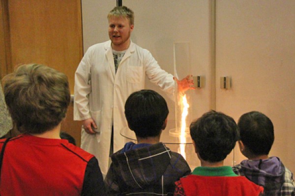 Youngsters crowd close to view the principle of angular momentum illustrated by a fire tornado during last year’s Science Rendezvous demonstrations.