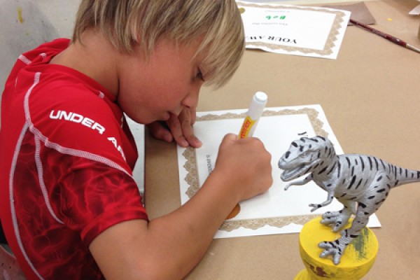 student working on dinosaur trophy