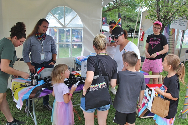 Pride volunteers hand out swag to children