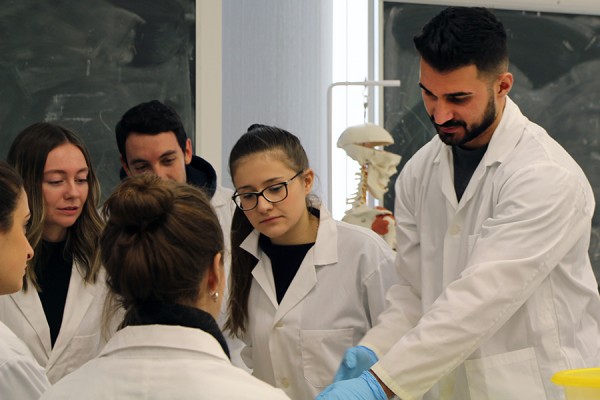 Biology students look on as teaching assistant Paul Bahnam conducts a tour through the human body.