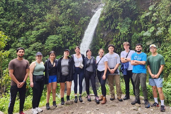 students stand before waterfall in Costa Rica