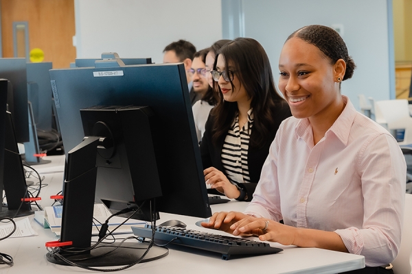 young women of Black and Indigenous heritage work on computers