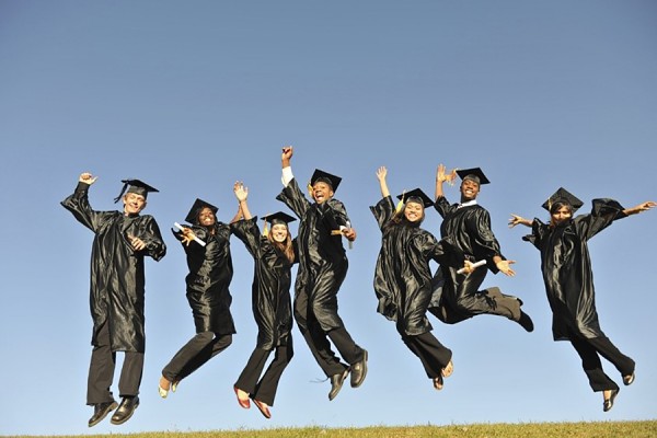 graduates a gowns jumping in air
