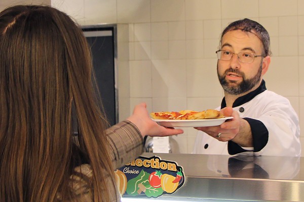 server handing food to student