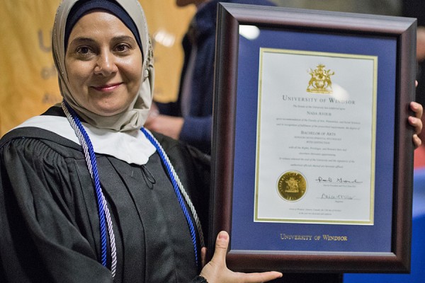 Proud grad holding framed diploma