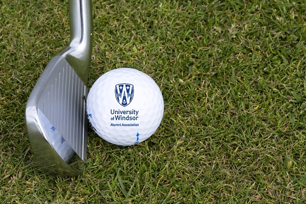 club striking golf ball bearing alumni association logo