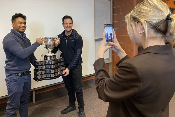 student poses for photo with Trevor Georgie and Memorial Cup