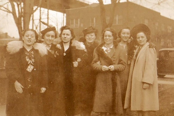 sepia-toned photo of young women under Ambassador Bridge