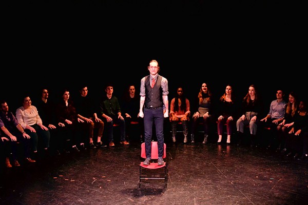 Jacob T. Free standing on a chair in circle of students