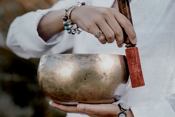 metal bowl being rung with a small mallet