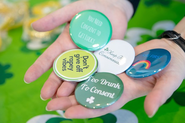 handfuls of buttons bearing messages about sexual consent