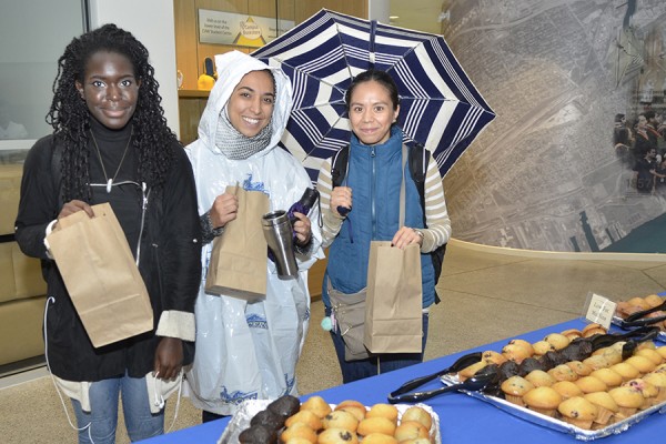 Students Vanessa Francis, Aicha Hassani, and Laura Cordovan pick up the makings of a continental breakfast marking the start of Alumni Weekend.