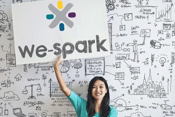 Young woman holding WE-Spark sign