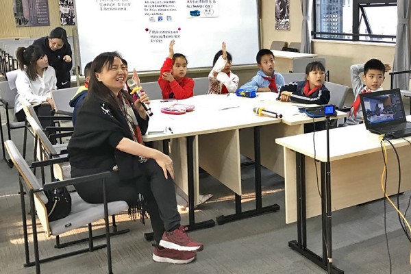 Education professor Shijing Xu sits in a Chongqing, China, classroom in 2019, using Skype to meet with a sister school in Windsor.