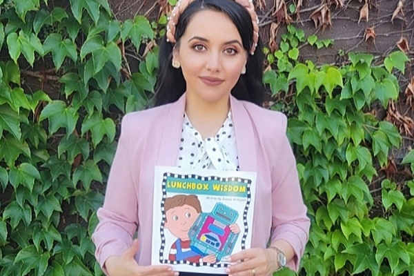 Zaynab Al-Yassiri holds a copy of her book Lunch Box Wisdom