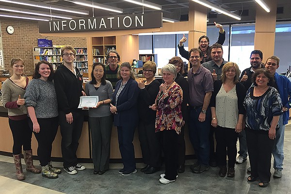 Leddy Library staff are all thumbs-up as Club SODA president Billy Chandler presents them with a certificate of appreciation for their work.