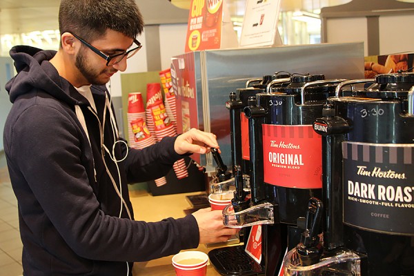 man pulls lever on coffee urn