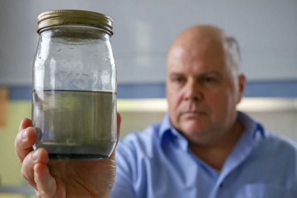 UWindsor&#039;s Joel Gagnon, associate professor and department head of Earth and Environmental Sciences, examines a sample of well water taken from a residence in Chatham-Kent.