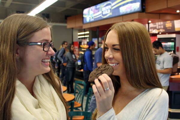 Celina Djikhuizen looks on as her friend Darien Slater samples a gluten-free cookie.