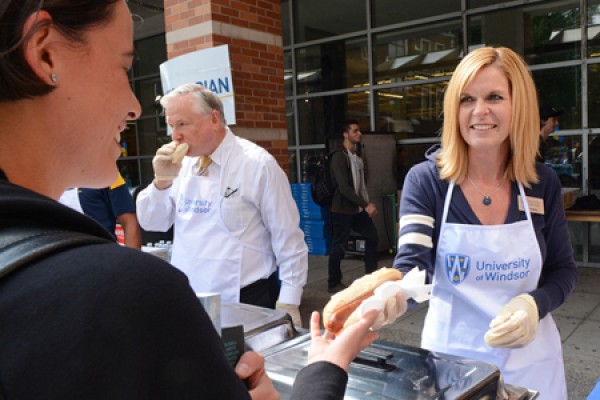 Beth Oakley hands a vegetarian hotdog to a student