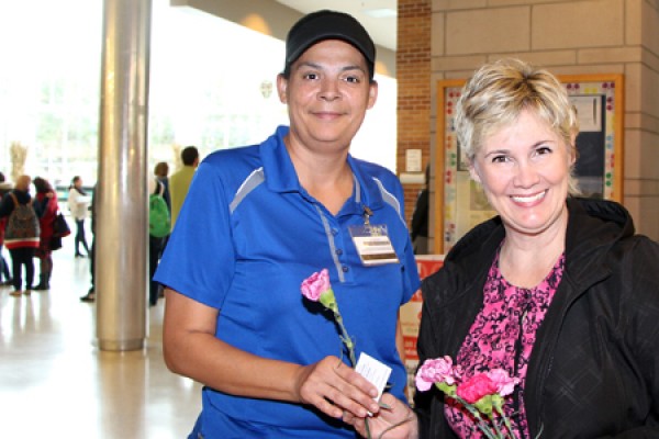 Food services worker Tracey Reardon accepts a flower from Lori Lewis