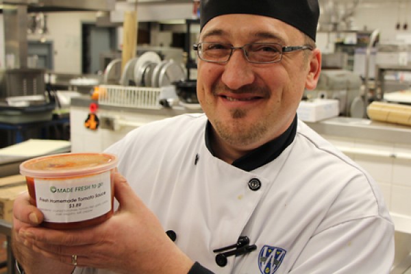 Peter Polak holding tub of tomato sauce