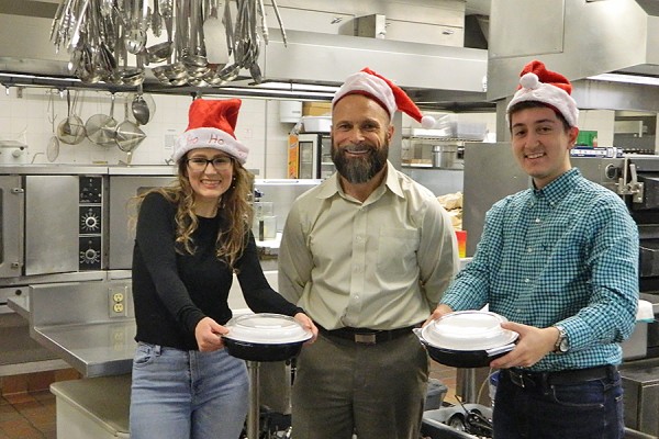 Catering manager Dean Kissner (centre) instructs students Victoria Mahon and Tedi Hoxha in food delivery in preparation for the December 12 ASB lunch service. 