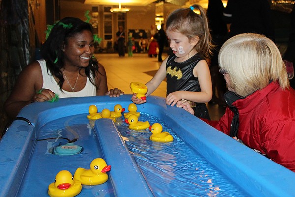 Residence student helps child play duck pond game